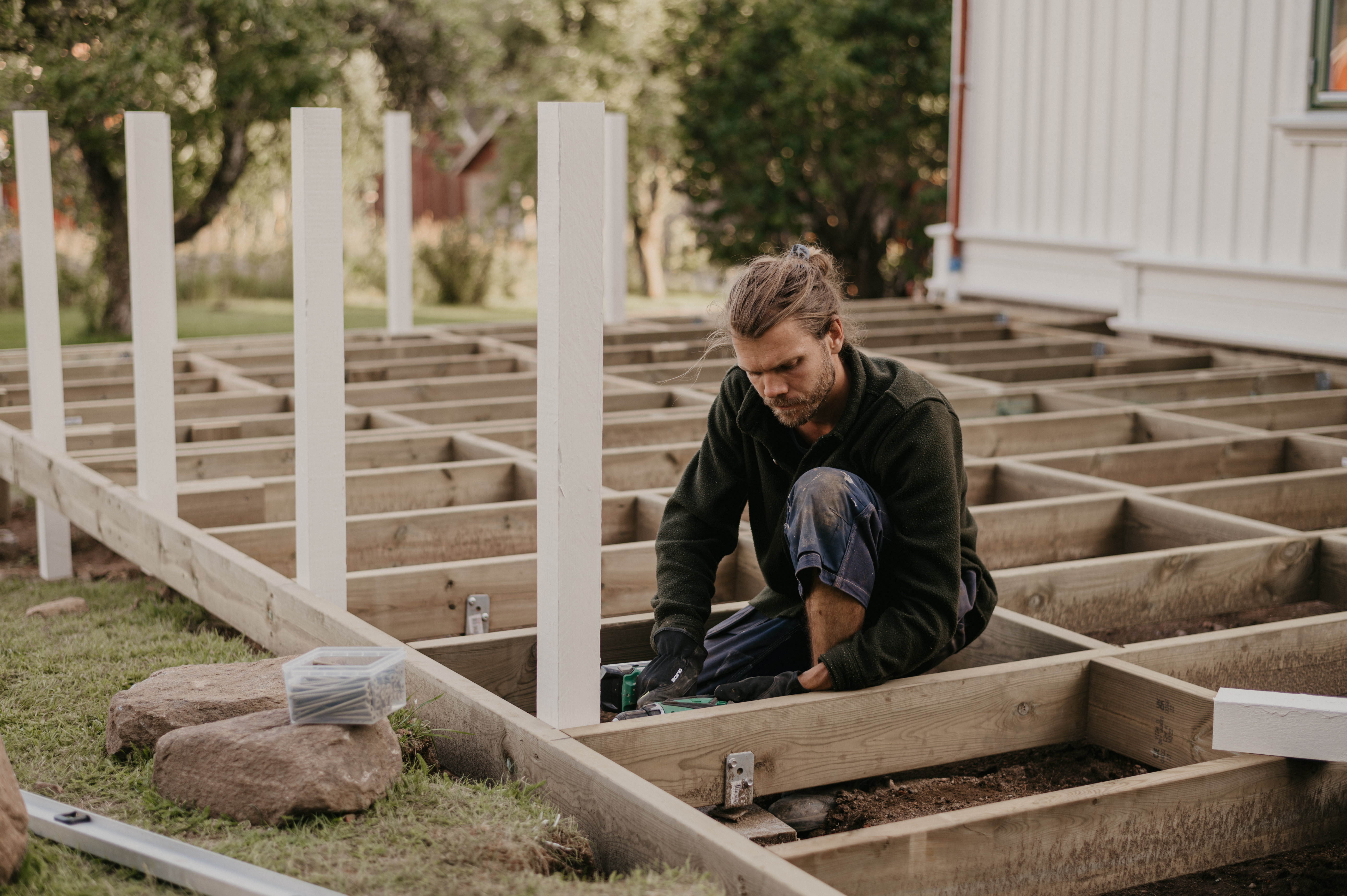 Här skruvar man fast stolpar till trallen i bjälklaget.