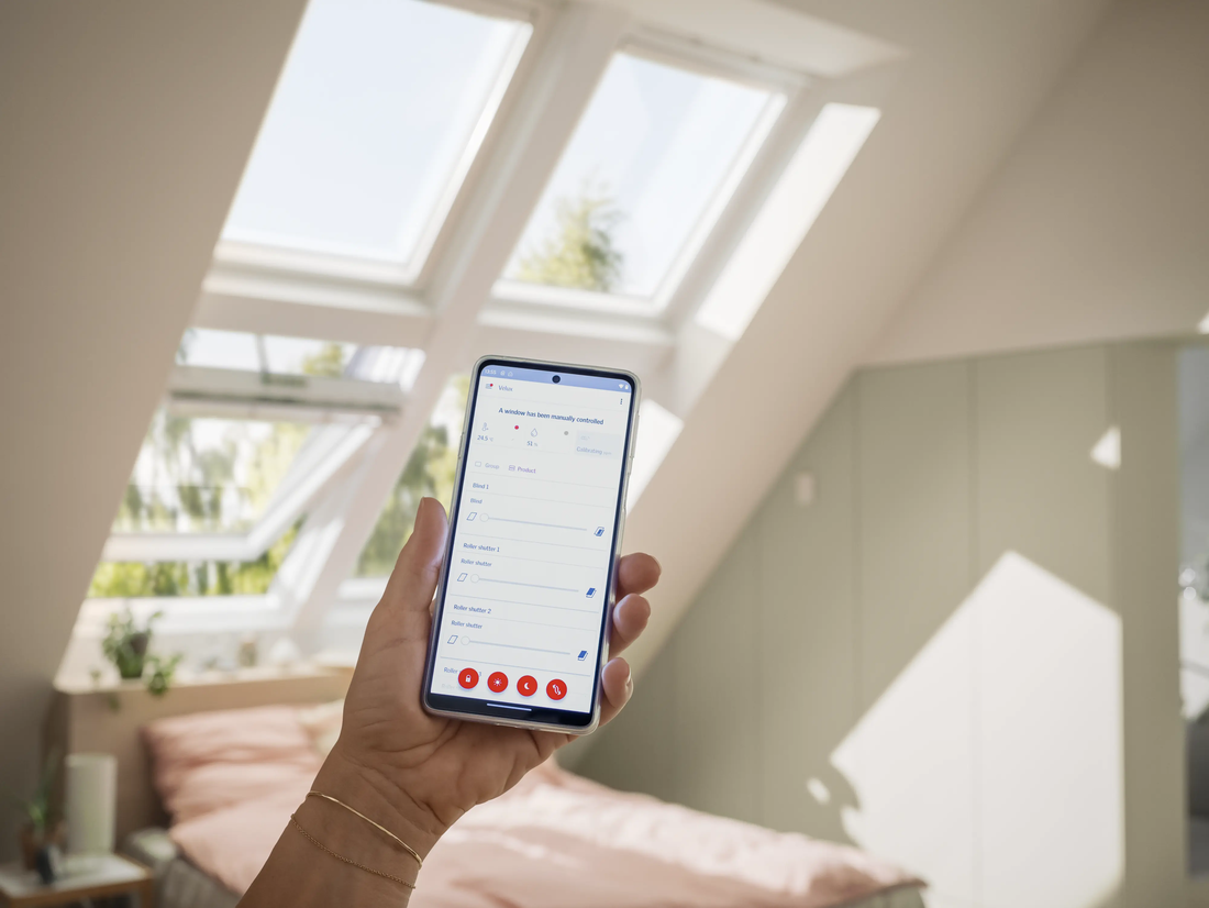 Hand som håller i en smartphone som visar applikation - Velux takfönster.