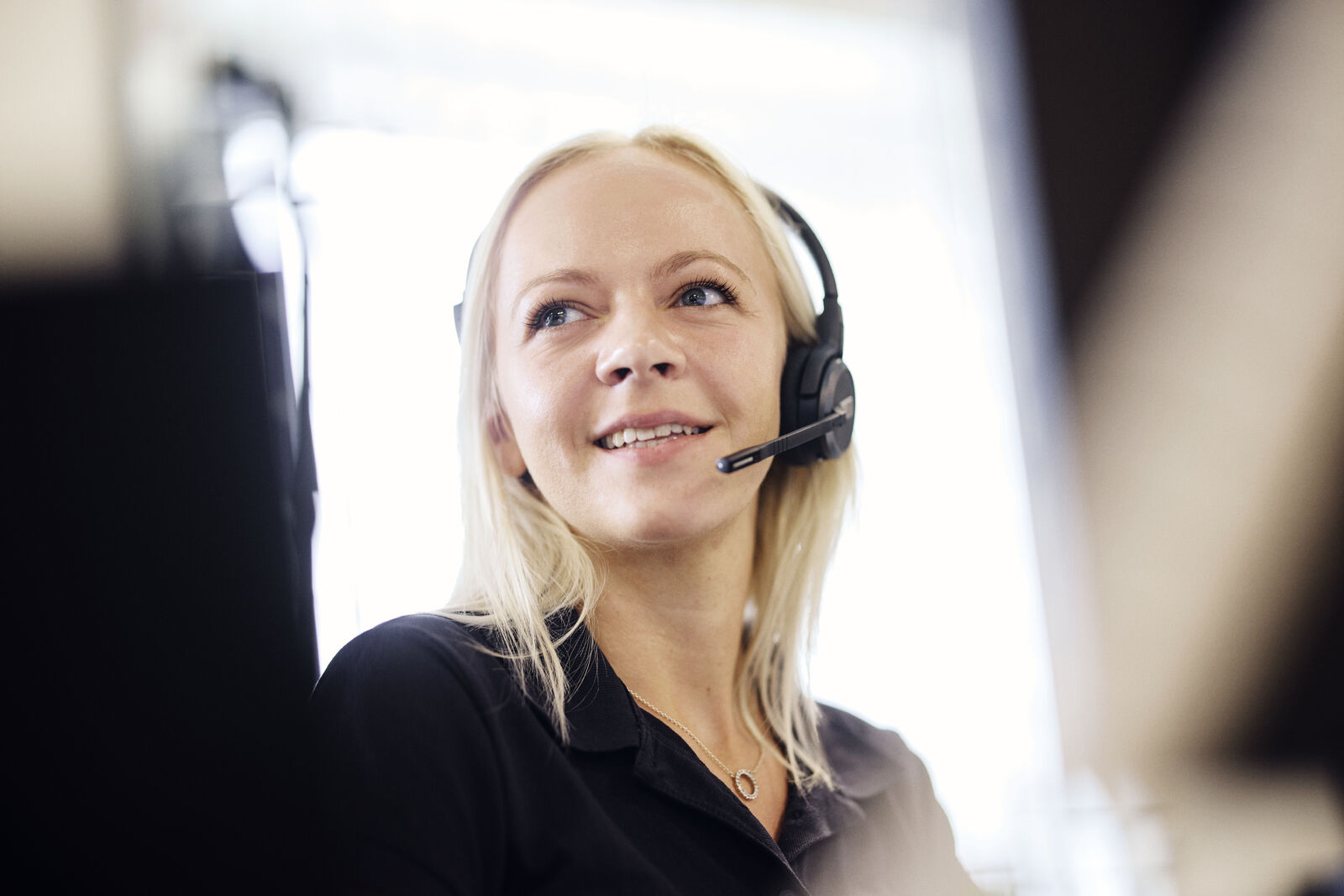 Person som sitter med headset och ger kundservice.