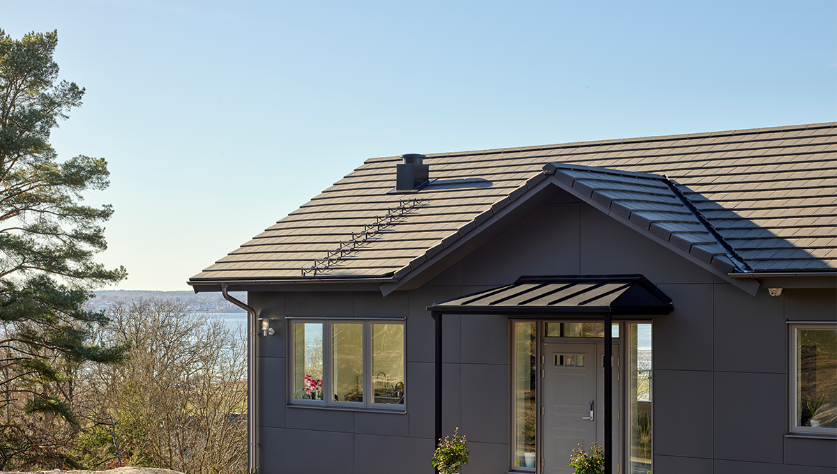 Villa med mörkgrått plåttak från Plannja.