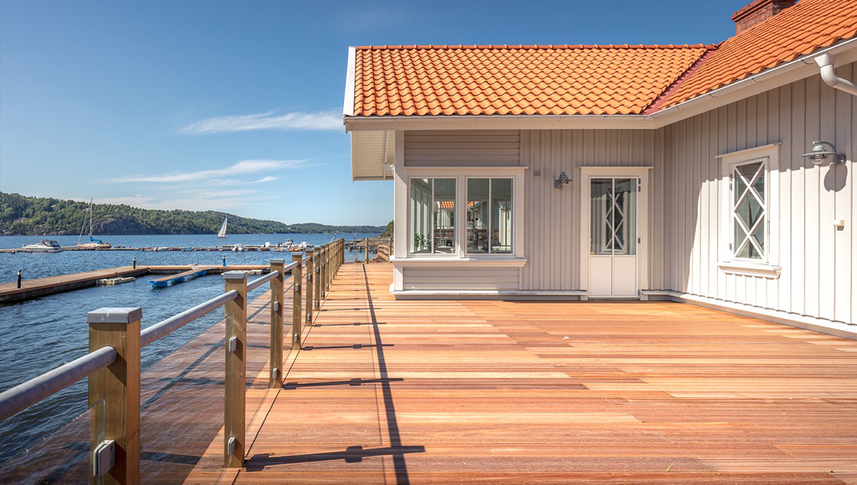 Träaltan vid strandnära hus med havsutsikt.